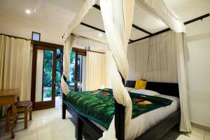 Postel nebo postele na pokoji v ubytování Batik Sekar Bali Guest House