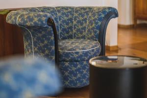 トレヴィーゾにあるLe Camere di Palazzo Bortolanのテーブル付きの客室で、青と黄色の椅子が備わります。