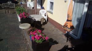 un patio con fiori, tavolo e ombrellone di Gudrun a Usingen