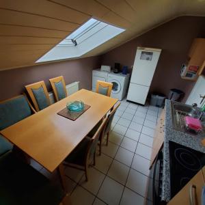 cocina con mesa, sillas y nevera en Gerlinde, en Usingen