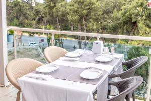 una mesa con platos blancos y una batidora en el balcón en Selin Otel Belek, en Antalya