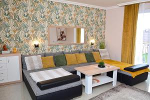 a living room with a couch and a table at Unicum Apartman in Hajdúszoboszló