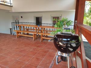 a grill and a bench on a porch at BM Apartman in Zalakaros