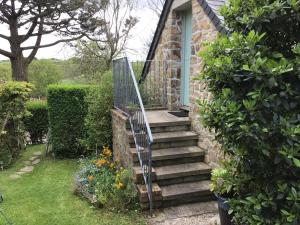 een stenen huis met een trap naar een deur bij Cozy Camborne Studio Retreat with two single beds in Camborne