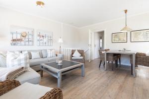 a living room with a couch and a table at C-Haus Cosima, App 80 in Wenningstedt