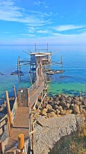 une promenade en bois menant à une maison sur l'eau dans l'établissement CRISTIAN House, à Vasto