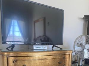 a television on top of a dresser with a fan at Die Kliphuis in Standerton
