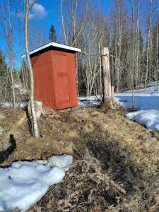 a red box sitting on top of a snow covered field at Isokummun Foresta in Sievi
