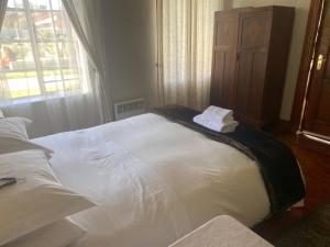 sypialnia z dużym białym łóżkiem i oknem w obiekcie Die Kliphuis w mieście Standerton