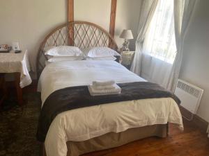 a bedroom with a bed with two towels on it at Die Kliphuis in Standerton
