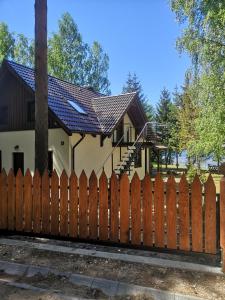 una valla de madera frente a una casa en Apartament Pod Świerkami, en Małe Swornigacie