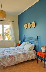 a bedroom with a bed and a blue wall at Villa Andoni in Othonoi