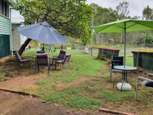 a group of chairs and a table with an umbrella at Meyenburg Units in Mount Morgan