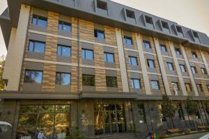 an office building with glass doors on a street at Medion Apartments in Tashkent