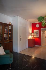a living room with a blue chair and a red wall at Nina's cozy apartment in Mikrolimano in Piraeus
