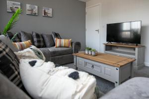a living room with a couch and a tv at Large Property & Contractors & Families & Garden & En-Suite in Rockingham