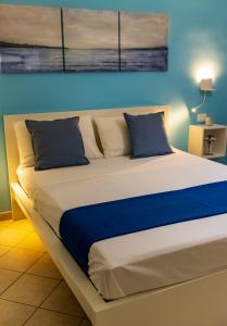 uma cama grande num quarto com uma parede azul em Blu Salina - Casa Vacanze em Margherita di Savoia
