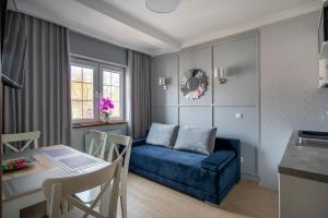 a living room with a blue couch and a table at Rowy Apartamenty Jantar 75 m od plaży in Rowy