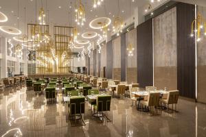 a banquet hall with tables and chairs and chandeliers at Chrysomare Beach Hotel & Resort in Ayia Napa