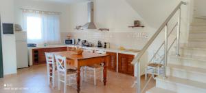 a kitchen with a wooden table and a staircase at Villa Andoni in Othonoi