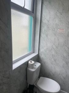 a bathroom with a white toilet and a window at Riversvale Hotel in Blackpool