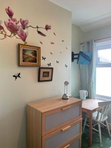 een kamer met een bureau en een tafel met bloemen aan de muur bij Riversvale Hotel in Blackpool