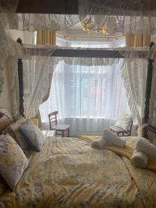 een slaapkamer met een hemelbed en een raam bij Riversvale Hotel in Blackpool
