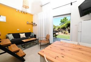 a living room with a couch and a table at YalaRent Valley view Boutique cottages with Pool in Merhavyāh