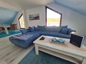 uma sala de estar com um sofá azul e uma mesa em Ferienwohnung Havenstern 61 em Bremerhaven