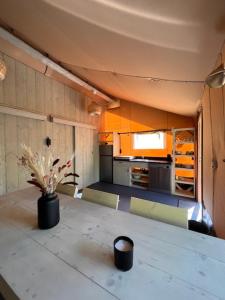 eine Küche mit einem Tisch und einer Blumenvase darauf in der Unterkunft Luxe Safaritent Medley 5 persoons op Camping Rijsterbos in Rijs