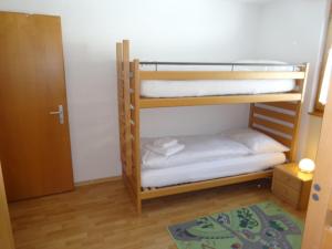 a bunk bed room with two bunk beds and a door at Abusunna Penthouse in Riederalp