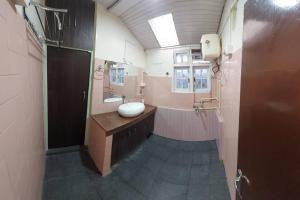 y un baño grande con lavabo y ducha. en Basnet Apartment, en Darjeeling