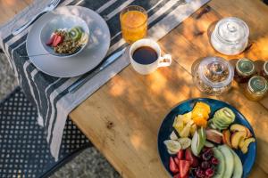 a wooden table with two plates of food and a cup of coffee at Luna Inn B&B in Corfu