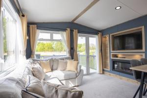 a living room with a couch and a tv at Cleethorpes Pearl Holiday Park in Humberston