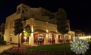 a large building at night with trees in front of it at Apartment Sunset Resort in Pomorie