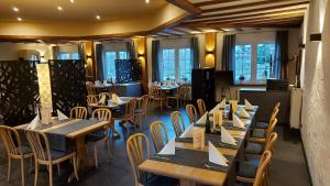 una sala da pranzo con tavoli, sedie e finestre di Hotel & Restaurant Brühler Hof a Wintrich