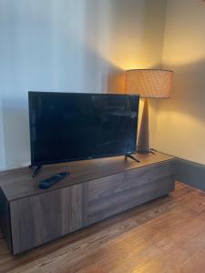 TV de pantalla plana en la parte superior de un centro de entretenimiento de madera en Appartement au calme et bow window quartier plage, en Mers-les-Bains