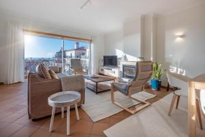 a living room with a couch and a table at Stunning Sea View Apartment Praia D'El Rey in Casal da Lagoa Seca