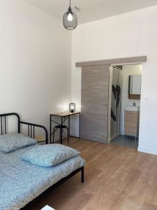 1 dormitorio con 2 camas, mesa y espejo en LA MAISON D'ANTONIN 2 en Nimes