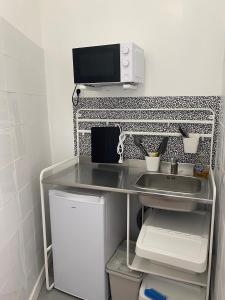 una pequeña cocina con fregadero y microondas en LA MAISON D'ANTONIN 2 en Nimes