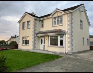 a large white house with a green lawn at Springfield Holiday Home in Carndonagh