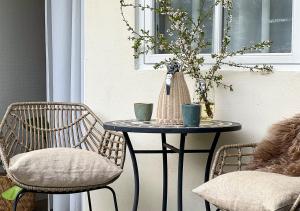 a table with two chairs and a table with two cups at Hotel Blomme's Place in Snogebæk