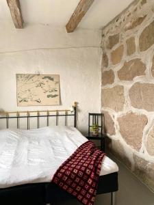 a bedroom with a bed and a stone wall at Villa Sandby B&B in Borrby