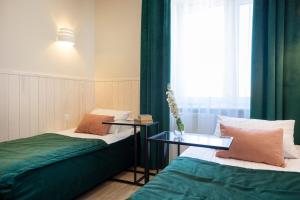 a room with two beds and a glass table at Szuflada Rooms in Augustów