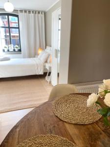 a room with a bed and a table with flowers on it at Lounge Club Apartment in Gdańsk