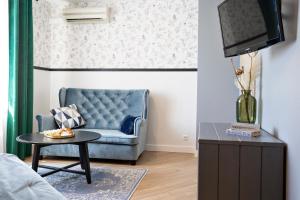 a living room with a blue couch and a table at Szuflada Rooms in Augustów