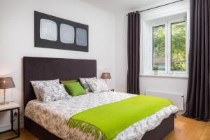 una camera da letto con un grande letto con una coperta verde di Charlie Chaplin a Spalato (Split)