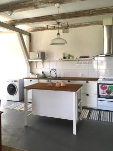 uma cozinha branca com um lavatório e um balcão em Villa Sandby B&B em Borrby