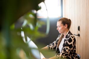 Una mujer sentada en una silla mirando por la ventana en Hotel Voramar, en L'Escala