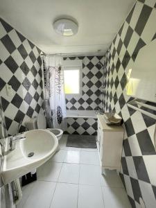 a black and white bathroom with a sink and a toilet at LA MAISON DE DELSY in Binson-et-Orquigny